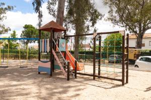 a playground with a slide in a park at Parque de Campismo Orbitur Evora in Évora