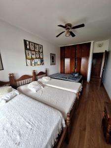 two beds in a bedroom with a ceiling fan at San Ignacio cattle farm Magdalena Buenos Aires in Estación Ignacio Correas +6 photos