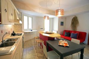 a kitchen and living room with a red couch at Appartamento Athena in villa 4pax in Marina di Ragusa