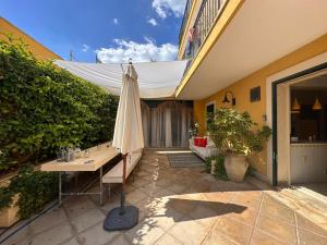 an umbrella sitting on a patio next to a building at Appartamento Athena in villa 4pax in Marina di Ragusa