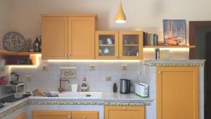 una cocina con armarios amarillos y fregadero en Studio Apartment Sicilia - 3pax, en Marina di Ragusa