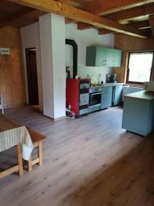 a kitchen with wooden floors and a large room at Székelyvarsági kulcsosház in Vărşag