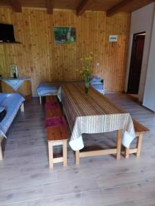 a wooden room with a table and chairs in it at Székelyvarsági kulcsosház in Vărşag