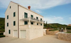 a white brick building with a balcony on it at Villa Apartments Mecajac in Cavtat