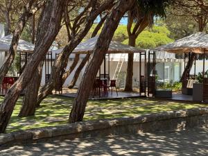 gazebo con sedie e tavoli sotto gli alberi di Parque De Campismo Orbitur Guincho a Cascais