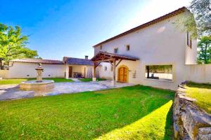 an exterior view of a house with a green yard at Villa Provençale - Rognes campagne d'Aix en Provence in Rognes