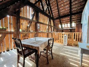 a dining room with a table and chairs in a barn at Herbes et collines in Winkel
