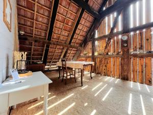 a room with a table in a barn with wooden walls at Herbes et collines in Winkel