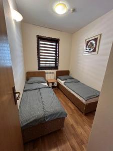 two beds in a room with a window at Premium Apartment in Fojnica +44 photos