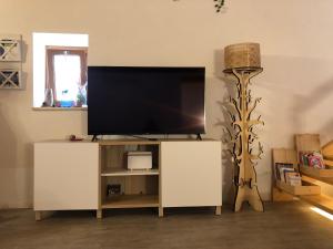 a living room with a flat screen tv on a stand at Verso Est in Petralia Soprana