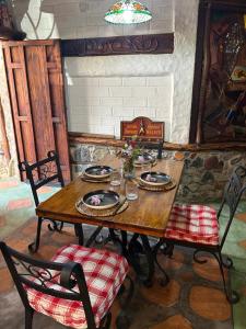 a wooden table and chairs in a room at La Cabaña del Abuelo in Lourdes