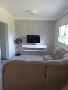 ein Wohnzimmer mit Couch und Flachbildfernseher in der Unterkunft Casa no Resort - Aguas de Santa Barbara in Águas de Santa Barbara