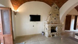 a living room with a stone fireplace and a tv at فيلا جاكرندا تونس Jacaranda Villa Tunis in Fayoum