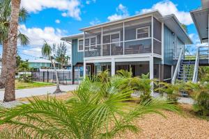 a house with palm trees in front of it at Beach Bungalow by Sun Palace Vacations in Fort Myers Beach