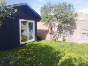 a black house with a window in a field of grass at Casa Giovanna in Puerto Natales