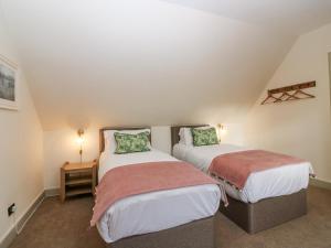 two beds in a small room with twoermottermottermott at Harmony Cottage - Harmony Gardens in Melrose