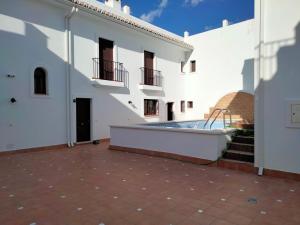 un patio con piscina en un edificio blanco en El Molino Alto de Álora Caminito del Rey, en Bermejo