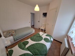 a small bedroom with a bed and a chair at Conero Cottage in Porto Recanati