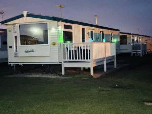 a large white house with a porch at night at Golden Sands Holiday Home in Skegness