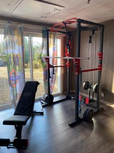 a room with a gym with a bench and a chair at La Jarria in Jurançon