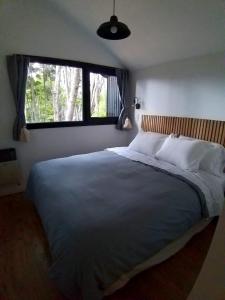 a bedroom with a large bed with a large window at Bosque Cipreses Sur in San Carlos de Bariloche +31 photos