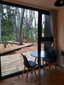 a room with a table and two chairs and a window at Bosque Cipreses Sur in San Carlos de Bariloche