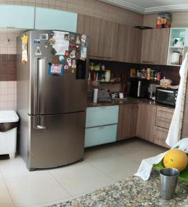 a kitchen with a stainless steel refrigerator with magnets at Casa hospedagem COP 30 3 quartos 01 suíte in Belém