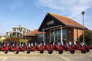a row of red motorcycles parked in front of a building at Orange Caprice, Church Farm in Pagham