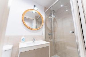 a bathroom with a shower and a sink and a mirror at Warm and Inviting, Central location by urbanhosting in Santander