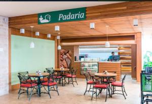 ein Restaurant mit Tischen und Stühlen vor einem Geschäft in der Unterkunft Casa no Resort - Aguas de Santa Barbara in Águas de Santa Barbara