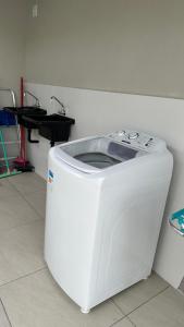 a white washing machine sitting on the floor in a room at House Box 05 in Itapema