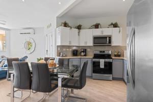 a kitchen and living room with a table and chairs at Newly Renovated Beachfront Condo with Inviting Minimalist Design, Pool & Balcony with Ocean Views in Playa Flamingo