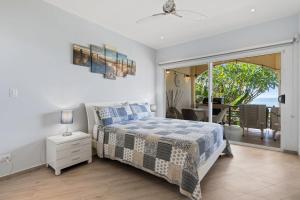 a bedroom with a bed and a view of the ocean at Newly Renovated Beachfront Condo with Inviting Minimalist Design, Pool & Balcony with Ocean Views in Playa Flamingo