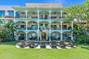 a large building with chairs and a pool at Newly Renovated Beachfront Condo with Inviting Minimalist Design, Pool & Balcony with Ocean Views in Playa Flamingo
