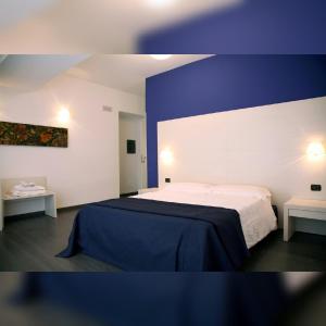 a bedroom with a bed and two tables at Areté Luxury Room in Reggio di Calabria