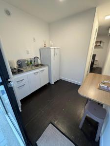 a small kitchen with a refrigerator and a table at House Box 06 in Itapema