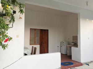 a white room with a door and a kitchen at Sengo House in Jomba