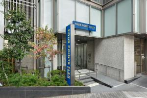 Four Points Flex by Sheraton Yokohama West في يوكوهاما: علامة زرقاء أمام المبنى