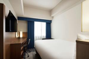 سرير أو أسرّة في غرفة في Four Points Flex by Sheraton Yokohama West