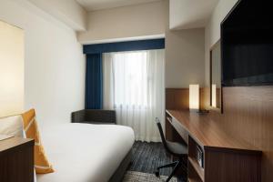 سرير أو أسرّة في غرفة في Four Points Flex by Sheraton Yokohama West