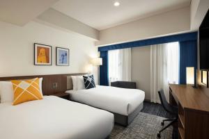 سرير أو أسرّة في غرفة في Four Points Flex by Sheraton Yokohama West
