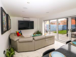 a living room with a couch and a flat screen tv at 4 Rockcliffe Grange in Mansfield