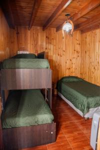 two bunk beds in a room with wooden walls at Casa Ezequiel in Villa Cura Brochero