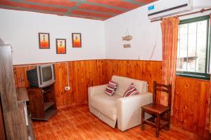 a living room with a chair and a tv at Casa Ezequiel in Villa Cura Brochero