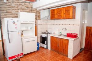 a kitchen with a white refrigerator and wooden cabinets at Casa Ezequiel in Villa Cura Brochero