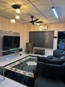 a living room with a couch and a tv at Rumah Iz Seksyen 20, Shah Alam in Shah Alam
