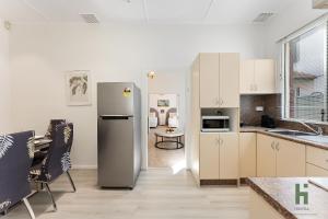 a kitchen with a stainless steel refrigerator and a table at edgeware house in Sydney