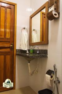 a bathroom with a sink and a mirror at Pousada Canastra Pai e Filho in São João Batista do Glória