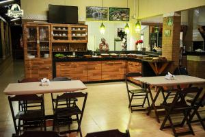 two tables and chairs in a restaurant with a counter at Pousada Canastra Pai e Filho in São João Batista do Glória