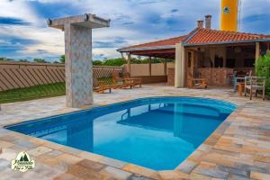 a swimming pool in a yard with a house at Pousada Canastra Pai e Filho in São João Batista do Glória +5 photos